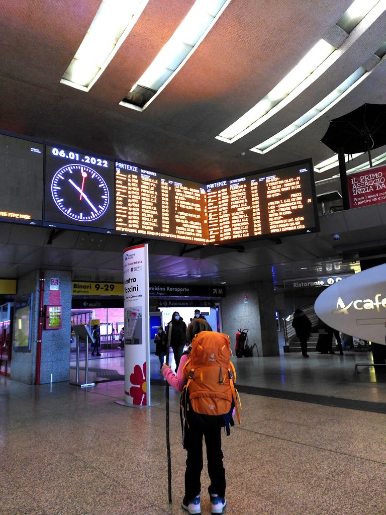 enfant regardant un panneau d'affichage dans une gare